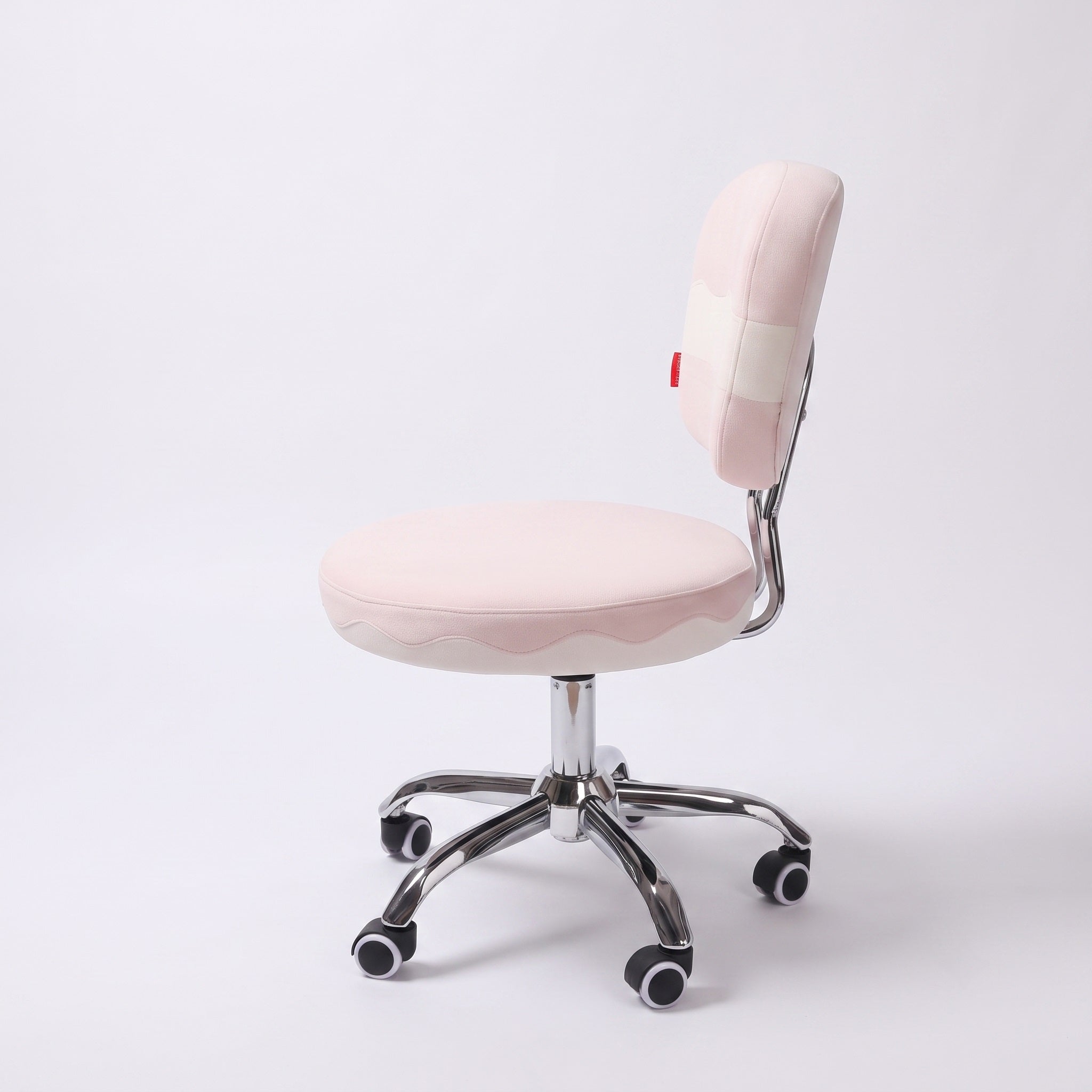 Side profile of adjustable height pink vanity chair with wheels